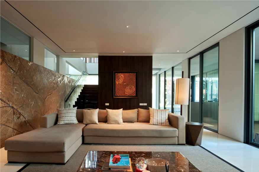 JE House living room with a golden-brown patterned feature wall and a cream corner sofa