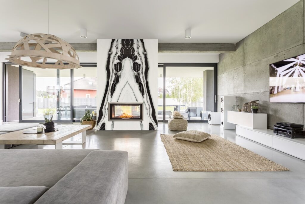 Modern living room with a fireplace wall clad in Mediterraneo Panda White, a symmetrical black-and-white pattern
